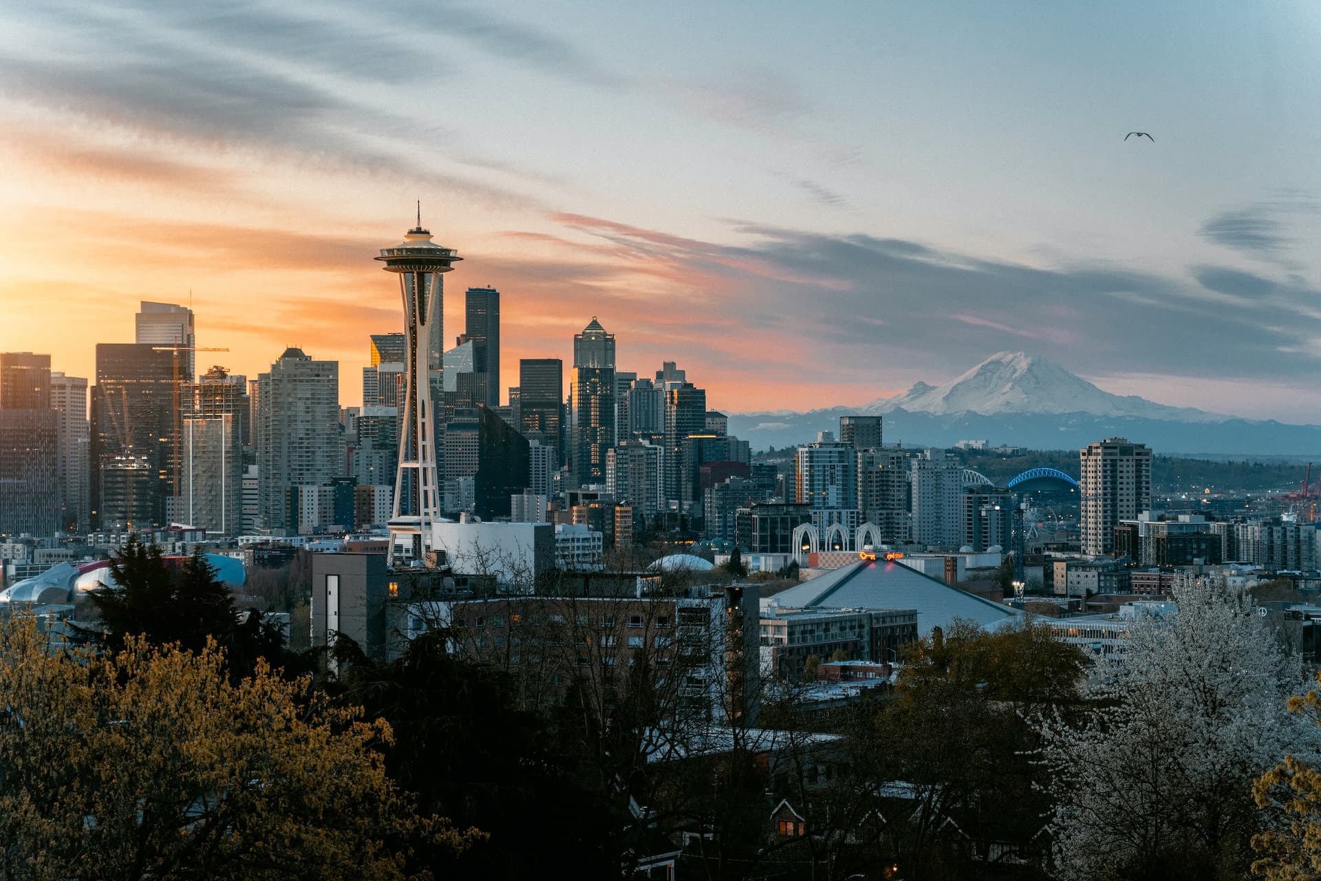 A sunset landscape photo of Seattle’s skyline from Kerry Park with downtown on the left and Mount Rainier on the right in the distance.